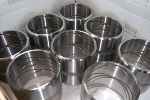 Finished metal cylinders with intricate cross-hatching, a testament to precision machining at SC Industries, Houston.
