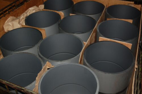 Finished metal cylinders with a protective coating, showing quality control at SC Industries.