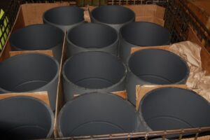 Finished metal cylinders with a protective coating, showing quality control at SC Industries.