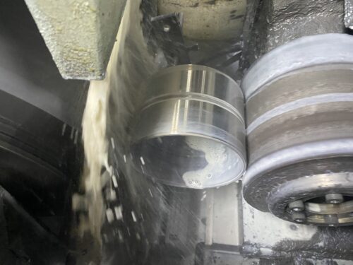 Coolant washing off a metal part after machining process, metal fabrication services at SC Industries in Houston.